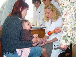 Доктор А. Троіліус оглядає українських пацієнтів